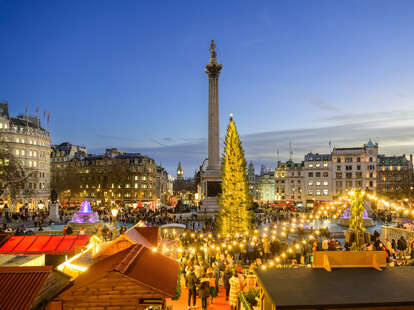 Trafalgar Square Christmas tree and festive market with Nelson's Column and Big Ben on shortest day of the year the winter solstice. 