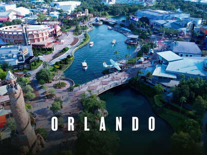 aerial shot of universal city walk in orlando, including a bridge, river, tower, and more