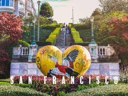 a yellow heart statue in front of a steep staircase at lyon street steps in san francisco, california