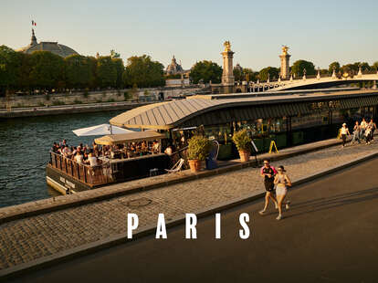 joggers run along the seine in Paris, France at sunset