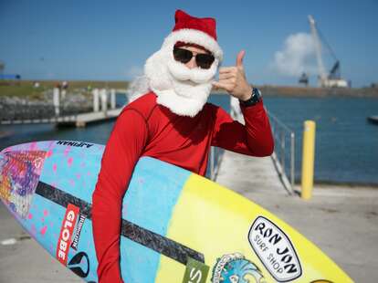 A surfer dressed as Santa.