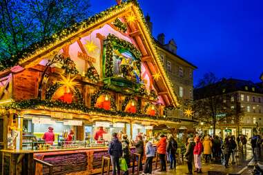 Customers at an ornate stall in a German Christmas market.