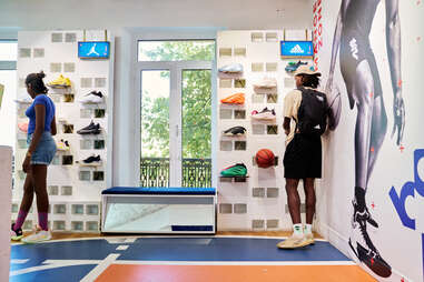 shoppers at a stylish sneaker store looking at Jordan brand and Adidas shoes in Paris, France