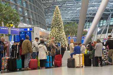 Flyers lined up in an airport at Christmas time.