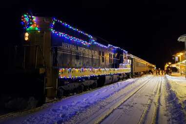 A train decorated with Christmas lights at night.