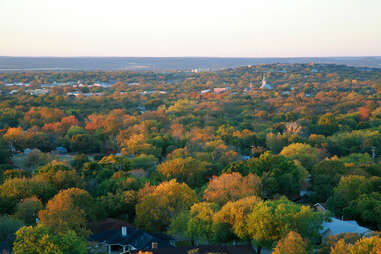 an aerial shot of the texas hill country landscape with fall colors showing in the trees