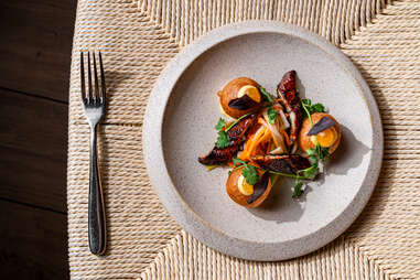 an ornate dish arranged on a plate, sitting on a fabric-covered table with one bright silver fork at moon rabbit in washington, d.c.