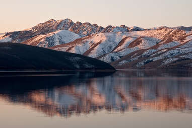 topaz lake in nevada next to snow-dusted hills and the pink glow of sunrise