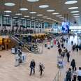 People walking through a large airport terminal